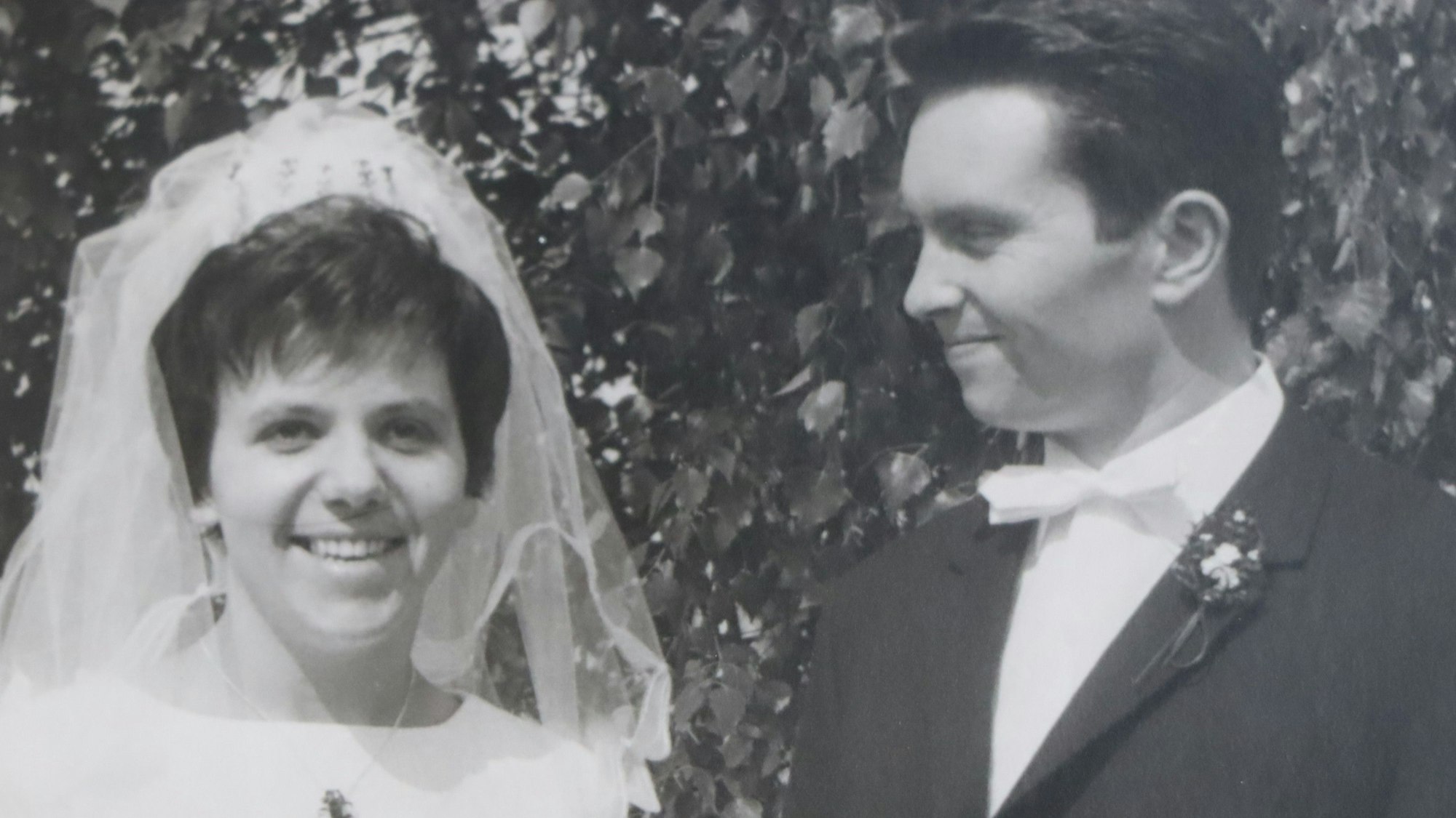 Ein Bräutigam schaut lächelnd seine Braut an.