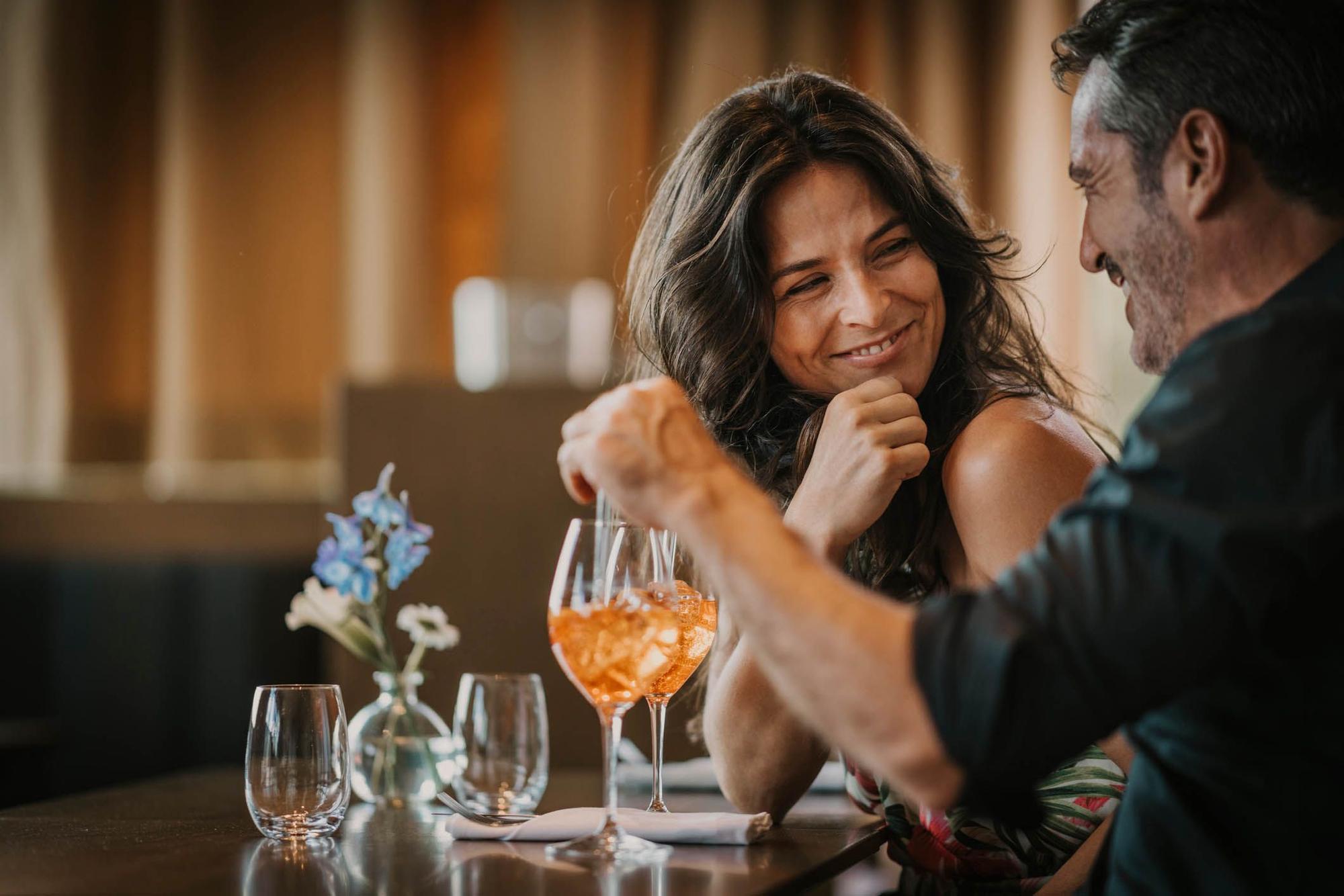 Glückliches Paar im Restaurant mit Cocktail. Bild zum Parship oder Elitepartner Online Dating Artikel.