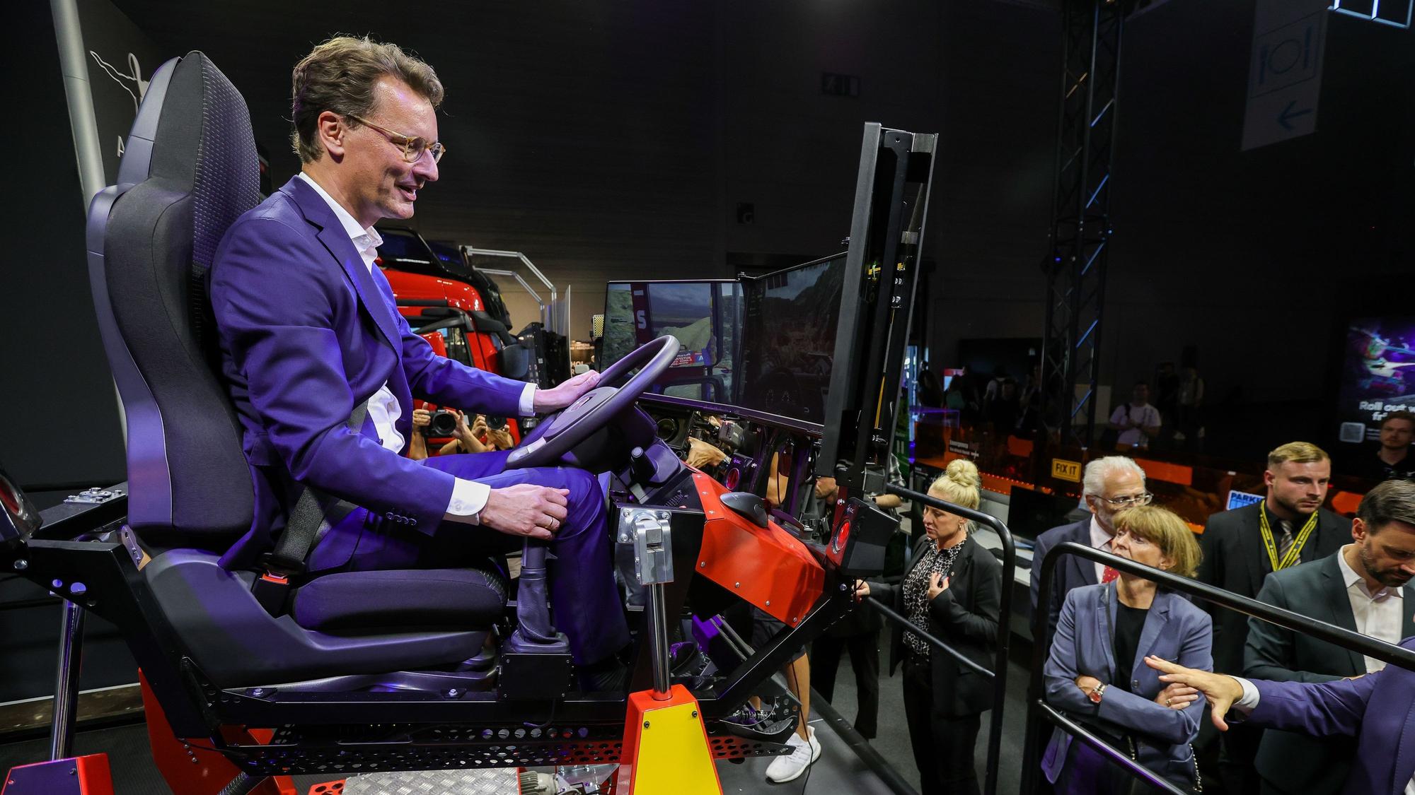 NRW-Ministerpräsident Hendrik Wüst probierte auf der Gamescom einen Heavy Duty-Simulator des deutschen Unternehmens Aerosoft aus.
