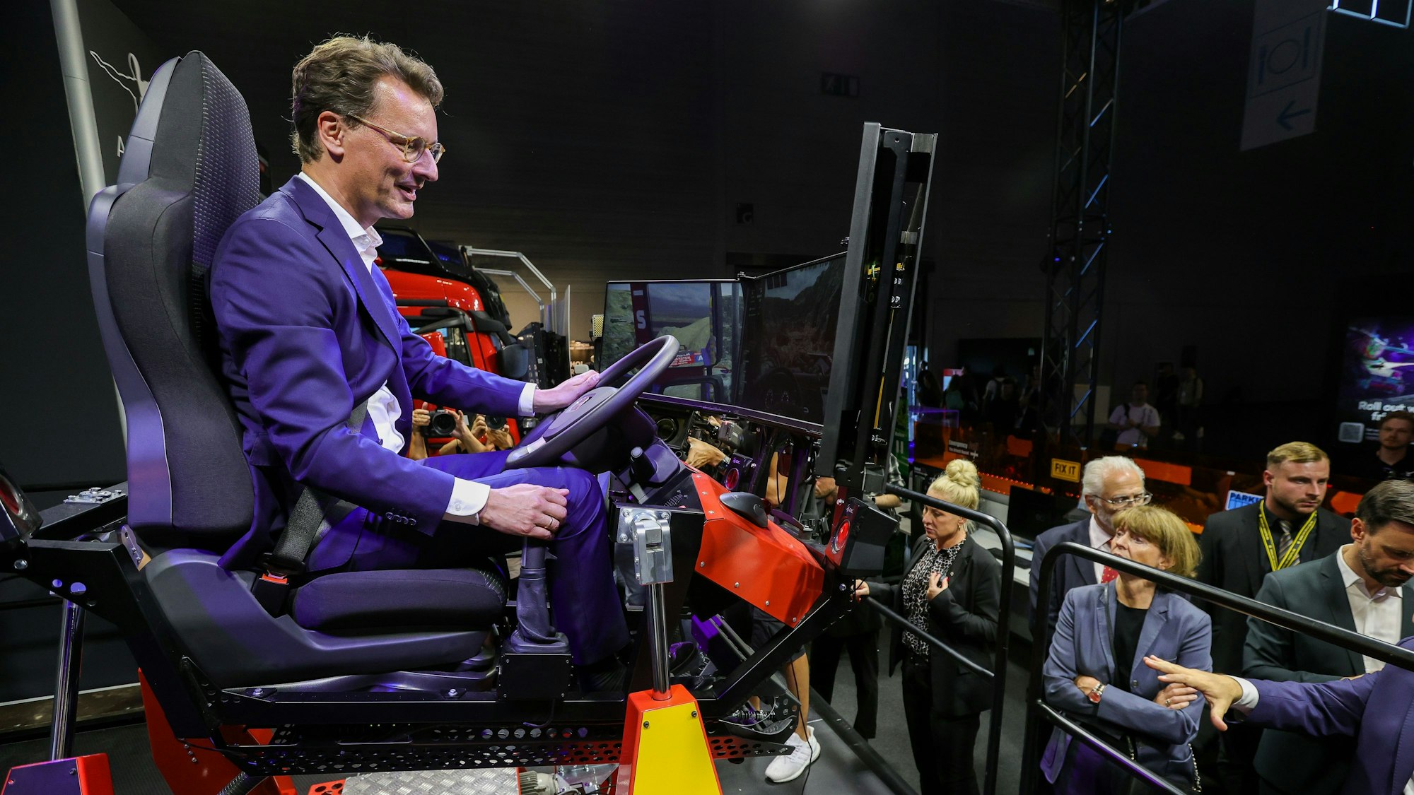 NRW-Ministerpräsident Hendrik Wüst probierte auf der Gamescom einen Heavy Duty-Simulator des deutschen Unternehmens Aerosoft aus.