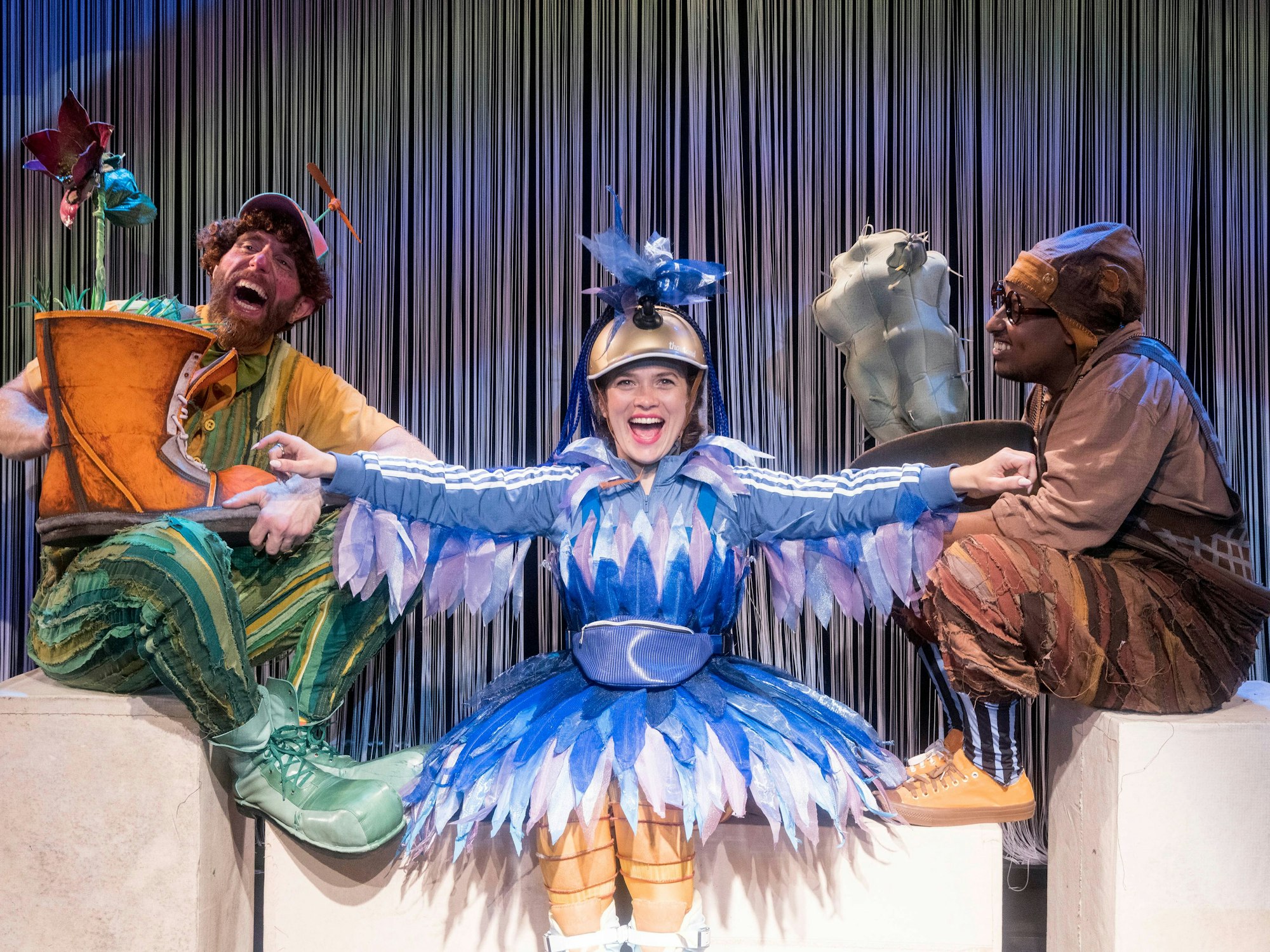 Drei Menschen in Kostümen: Ein Riese, ein Bär und eine Brücke.