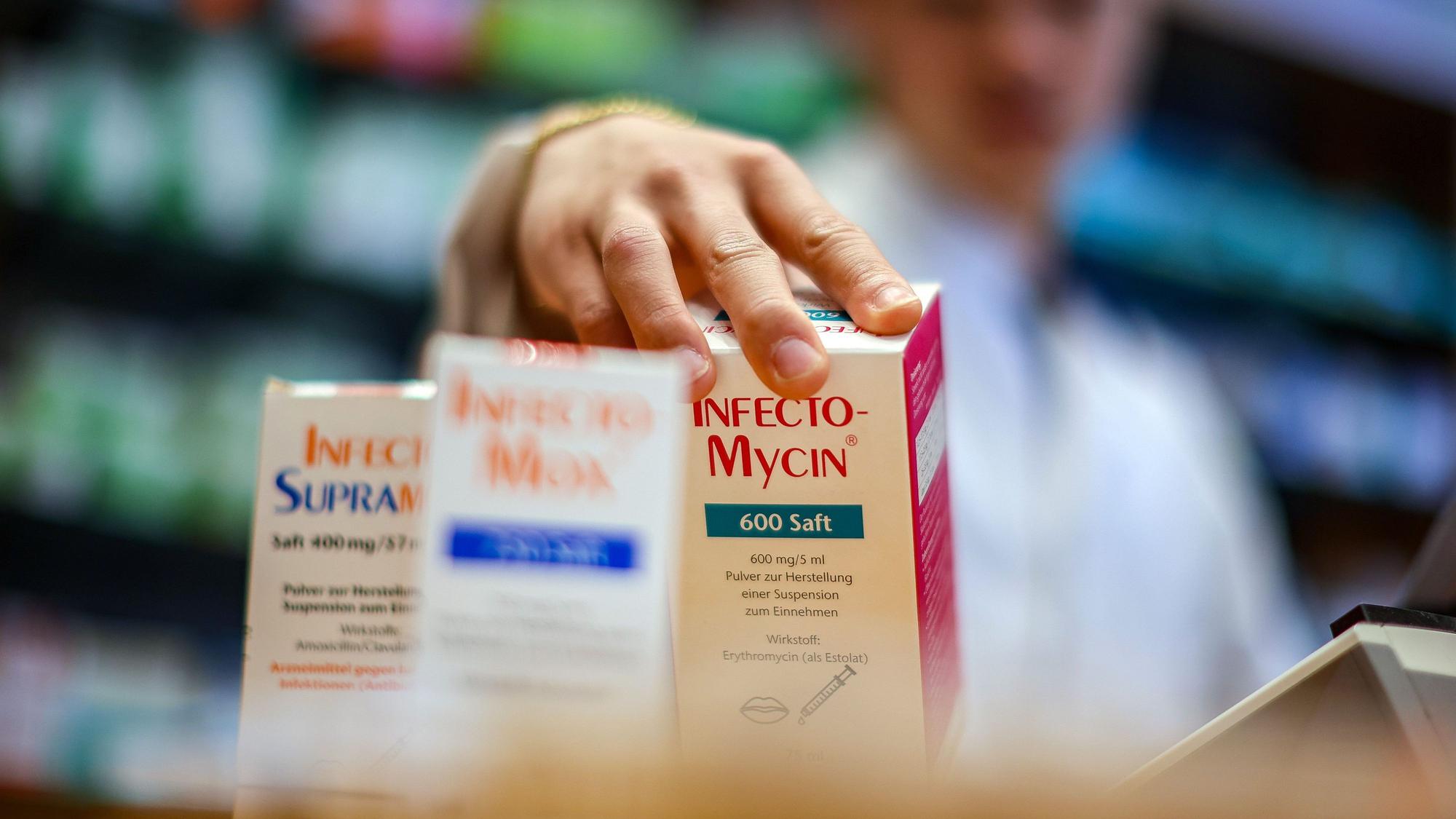 Ein Mitarbeiter einer Apotheke greift nach einer Packung Antibiotikasaft „Infectomycin“ für Kinder.
