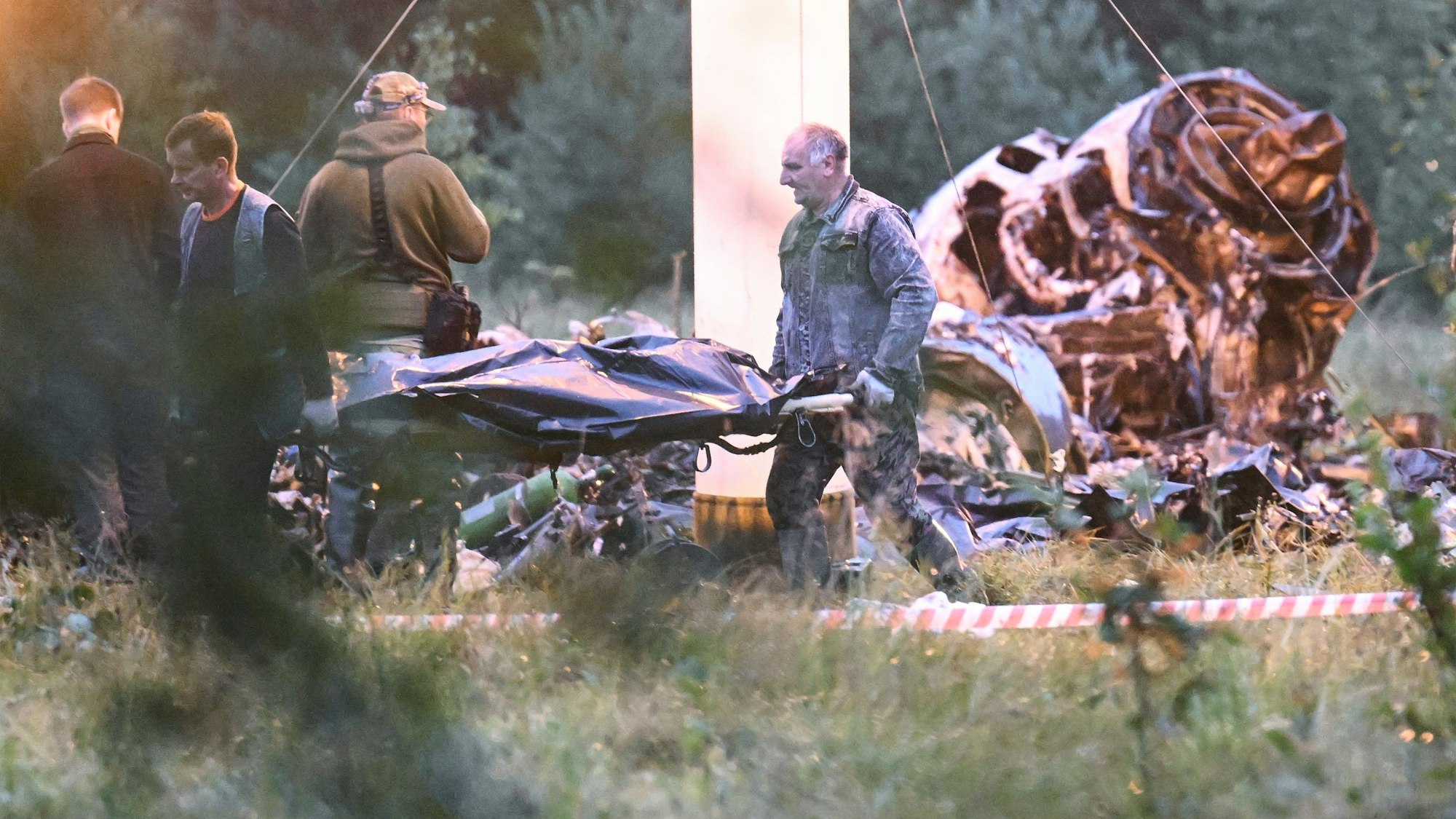 Menschen tragen einen Leichensack aus dem Wrack eines abgestürzten Privatjets in der Nähe des Dorfes Kuschenkino in der Region Twer. Der russische Söldnerführer Jewgeni Prigoschin ist nach Angaben seines Telegram-Kanals Grey Zone vom Mittwoch tot.