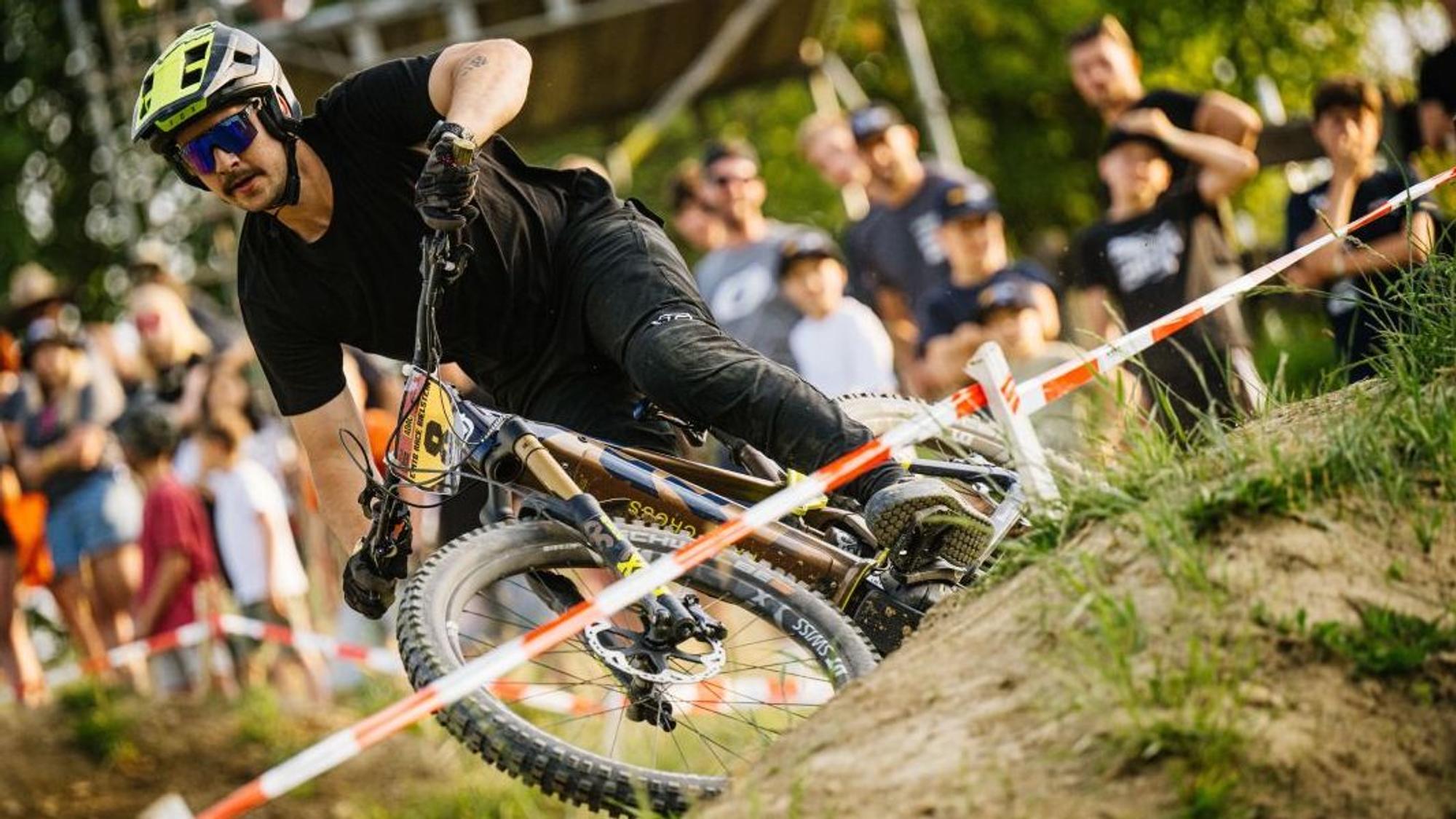 Erster E-Mountainbike-Fahrer nimmt eine Kurve auf der abgesteckten Strecke.