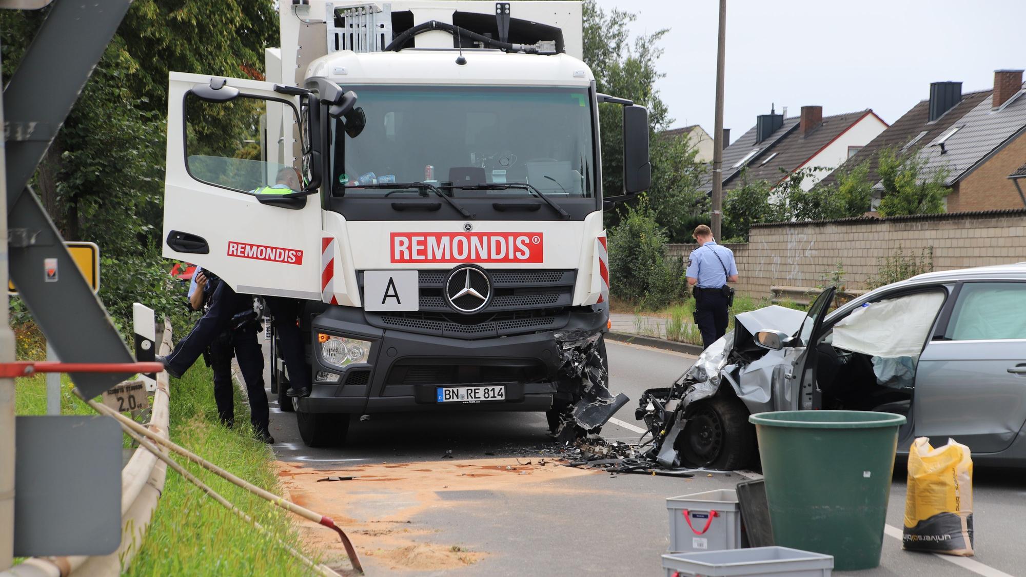 Ein Müllfahrzeug der Remondis, die linke Front ist beschädigt, daneben steht ein silberner Wagen, dessen Motorraum zusammengedrückt ist.