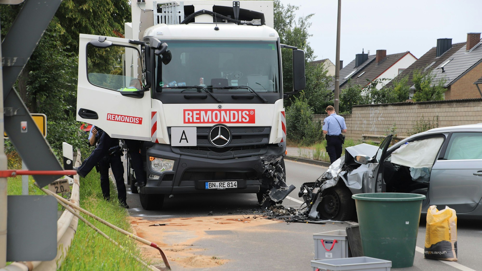 Ein Müllfahrzeug der Remondis, die linke Front ist beschädigt, daneben steht ein silberner Wagen, dessen Motorraum zusammengedrückt ist.