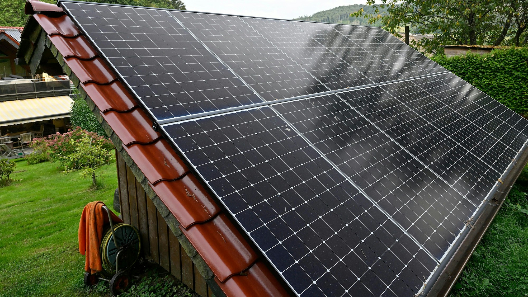 Photovoltaikanlage auf einem Dach eines kleinen Hauses.