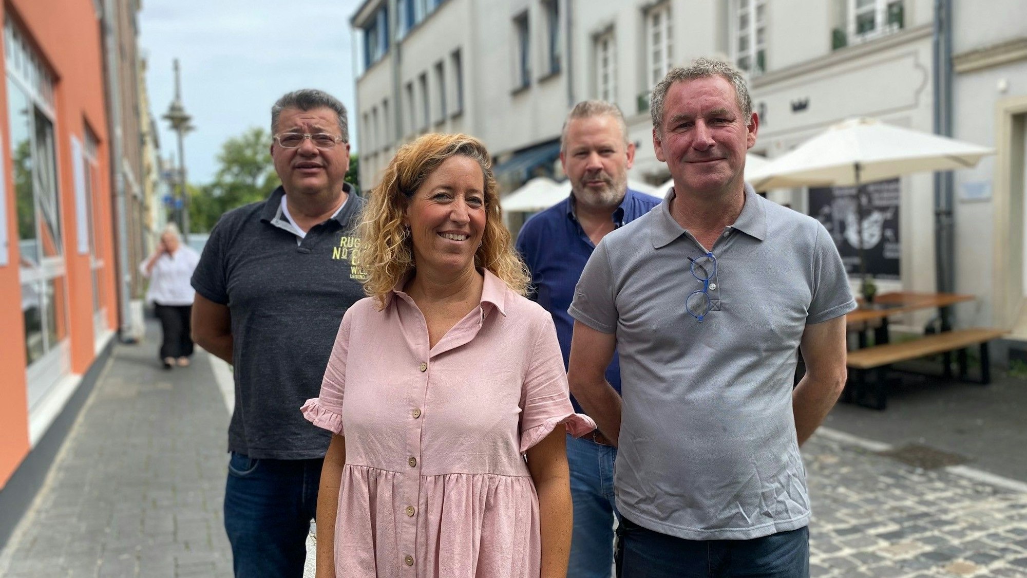 Das Bild zeigt drei Gastronomen und einen Geschäftsfrau, die auf der Burgstraße stehen. Im Hintergrund ist ein Restaurant zu sehen.