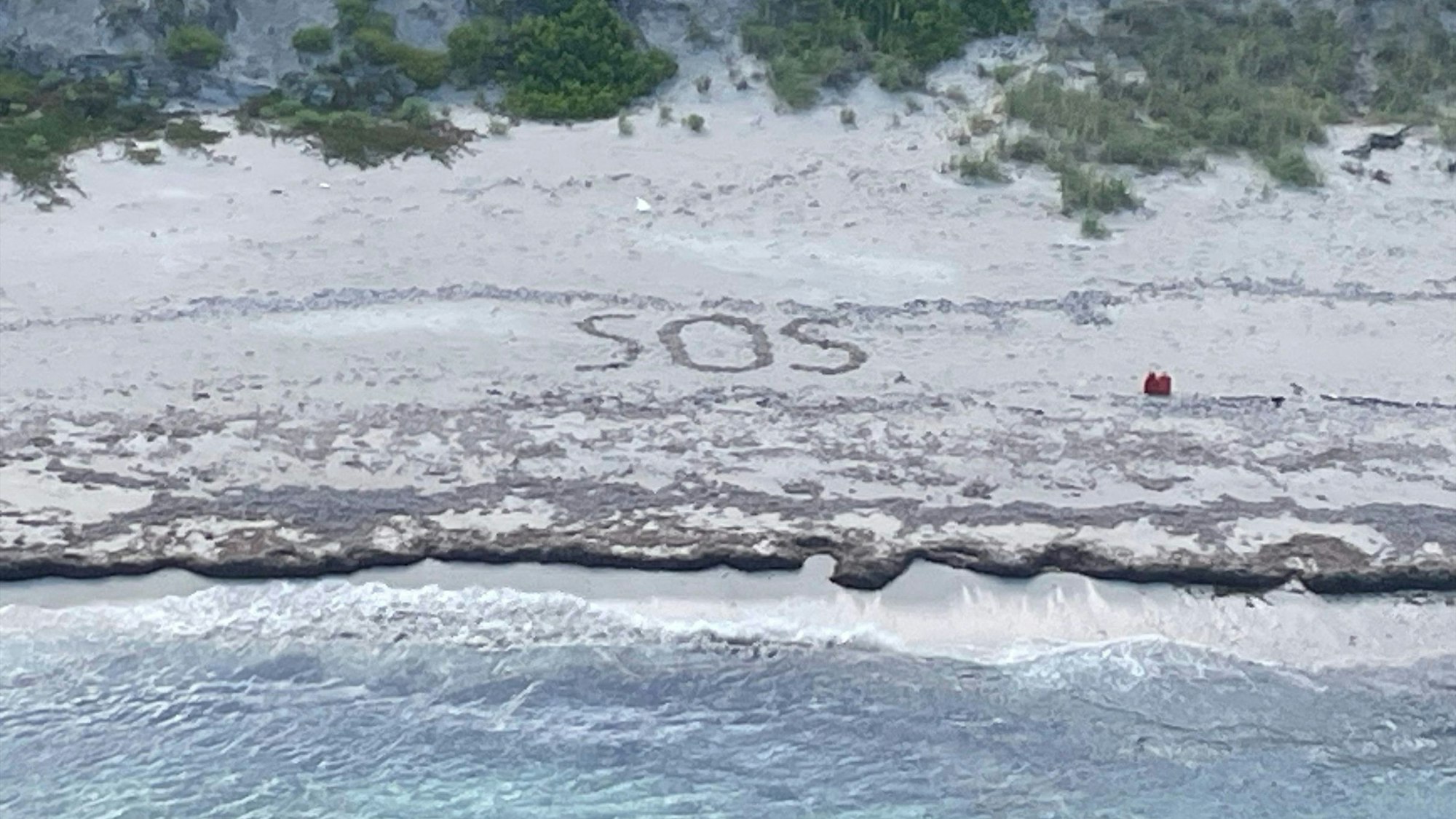 Das von der US-Küstenwache veröffentlichte Foto zeigt den SOS-Schriftzug im Sand der Bahamas-Insel Cay Sal, der zur Rettung eines Deutschen führte.