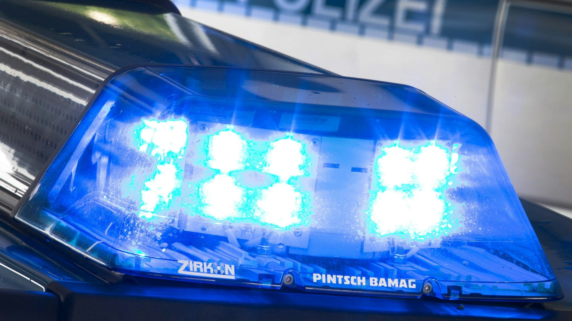 Auf dem Foto ist ein Blaulicht auf dem Dach eines Polizeiwagens zu sehen.