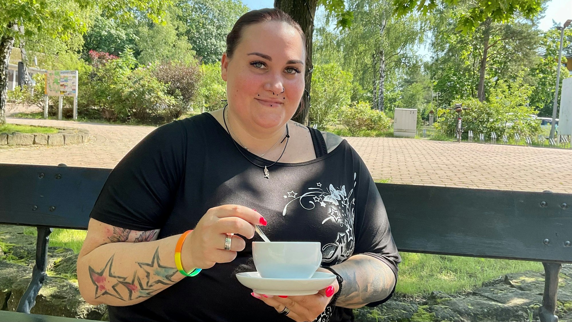 Frau auf der Bank mit einer Tasse Kaffee