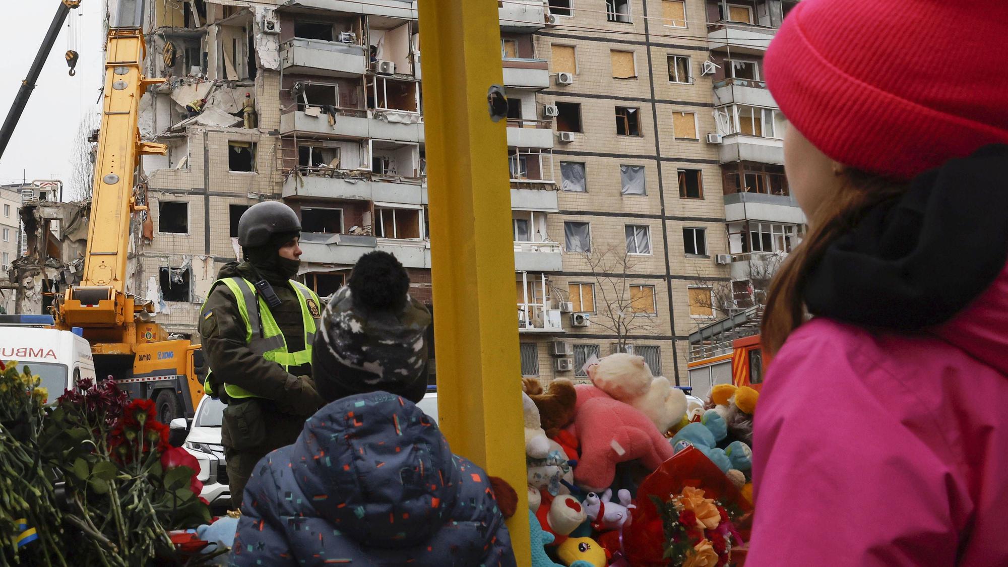 Scene in Ukraine Children look at an apartment building struck by a missile in Dnipro on Jan. 17, 2023, amid Russia's war on Ukraine.