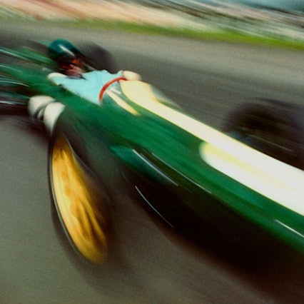 Fotografie eines grünen Rennautos, das durch die Geschwindigkeit verwischt und verzerrt wird.