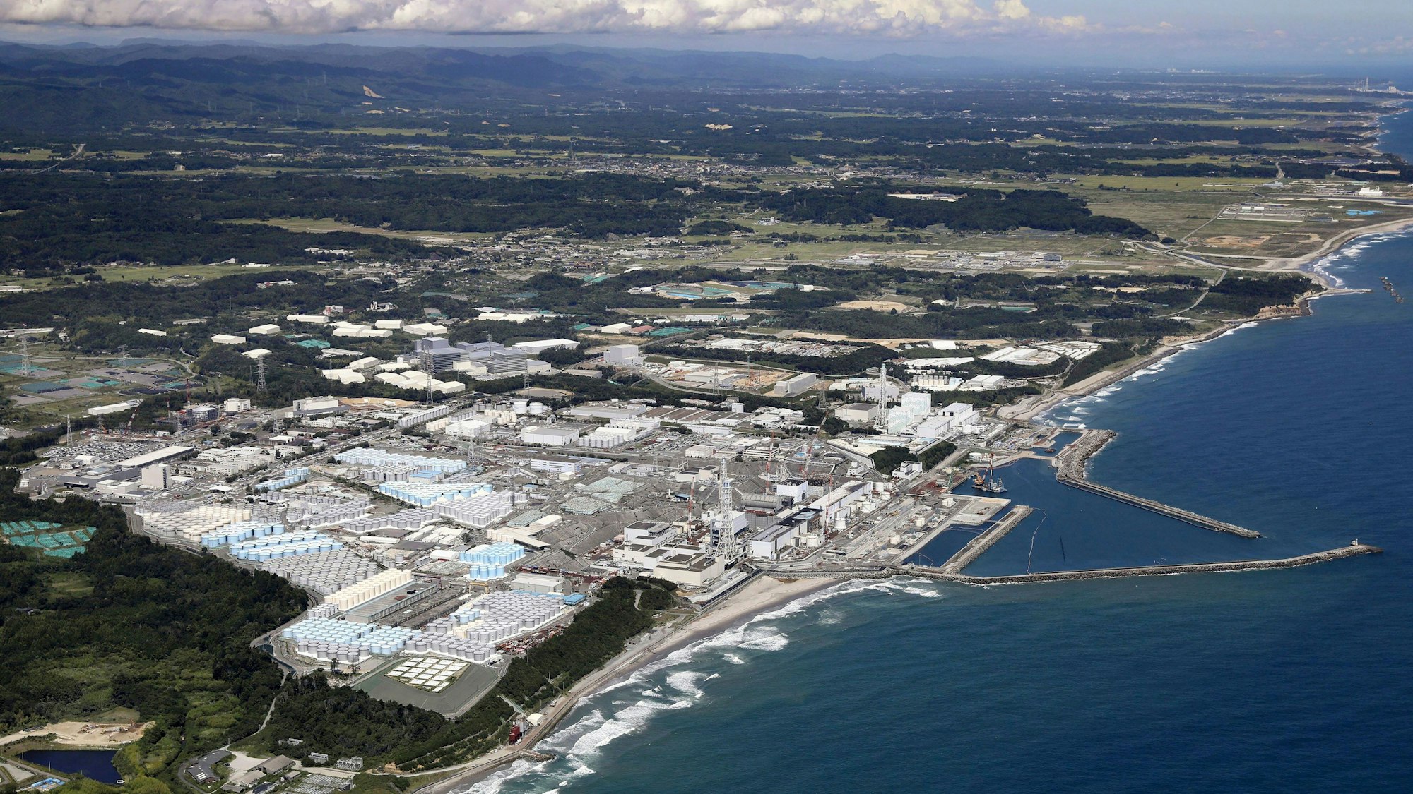 Diese Luftaufnahme zeigt die Tanks im Vordergrund, die die behandelten radioaktiven Abwässer des Kernkraftwerks Fukushima Daiichi in Fukushima, Nordjapan, am 22. August 2023 enthalten.