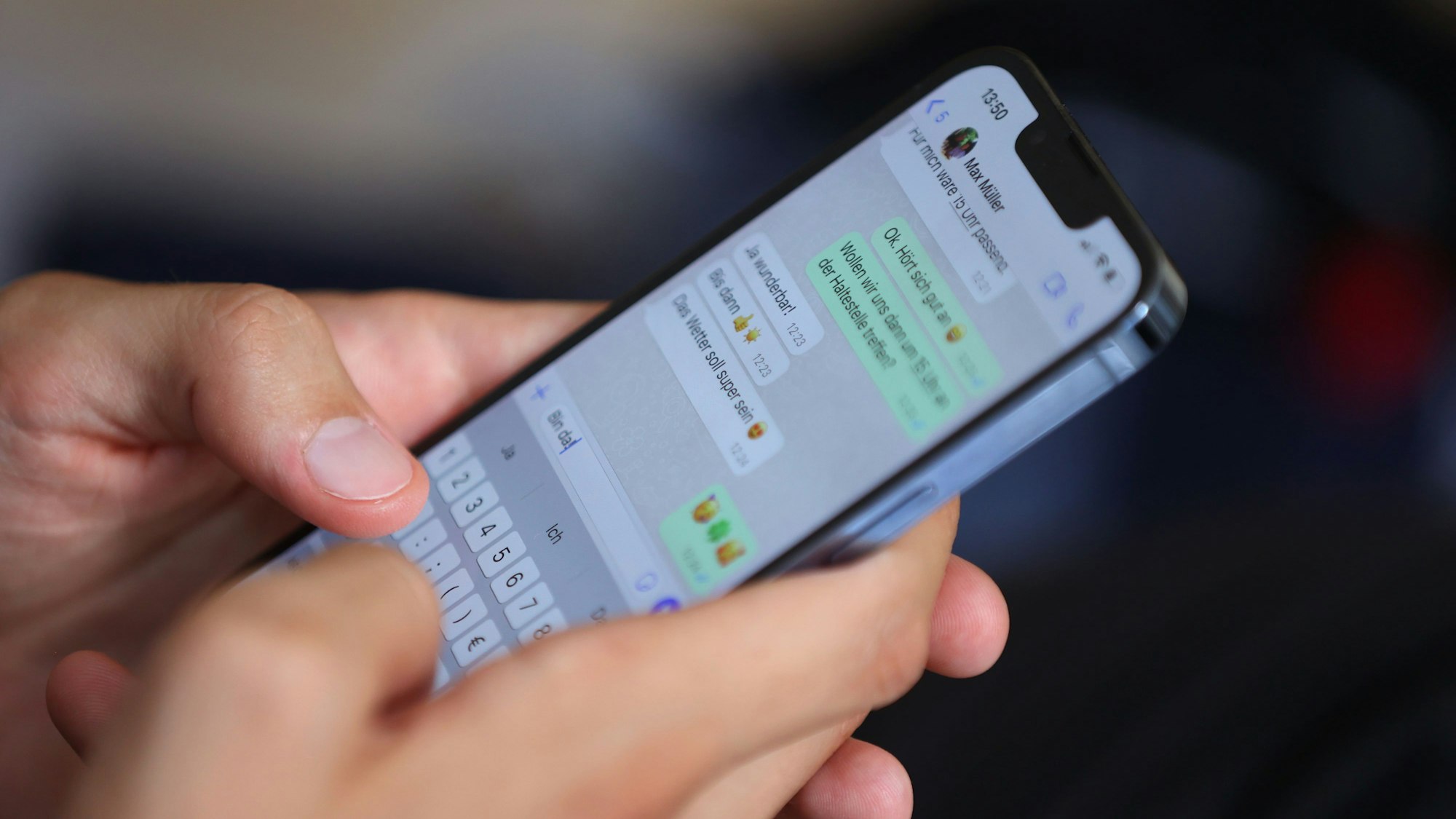 Ein junger Mann tippt auf einem Smartphone eine WhatsApp Nachricht.