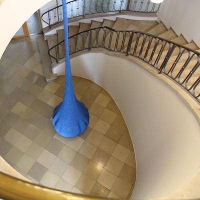 Ein tropfenförmiges blaues Kunstprojekt hängt in einem Treppenhaus des Katholisch-Sozialen Instituts (KSI) in Siegburg