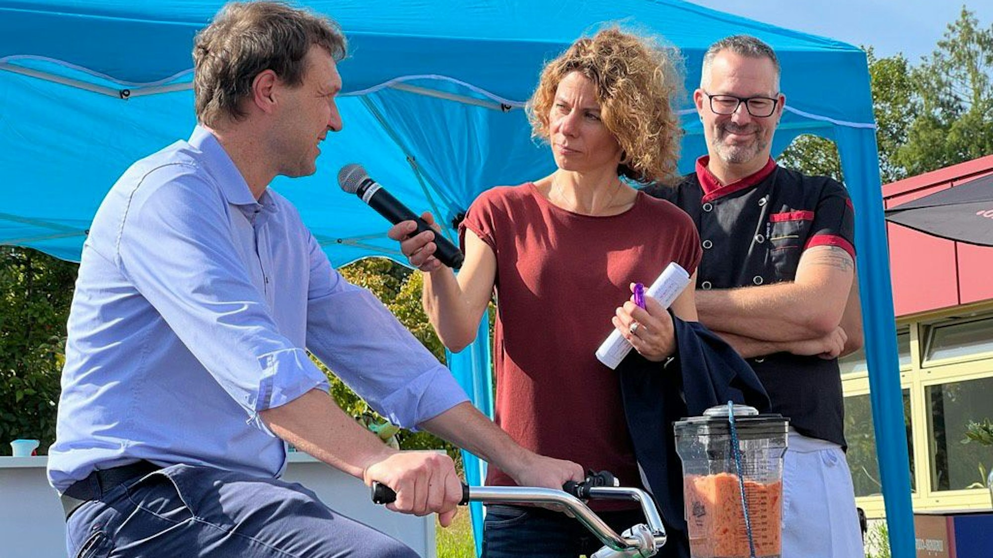 Alexander Lünenbach (l.) im Gespräch mit Anke Feller, während er in die Pedale tritt, um für Dino Engelhardt (r.) eine Gazpacho zu pürieren.
