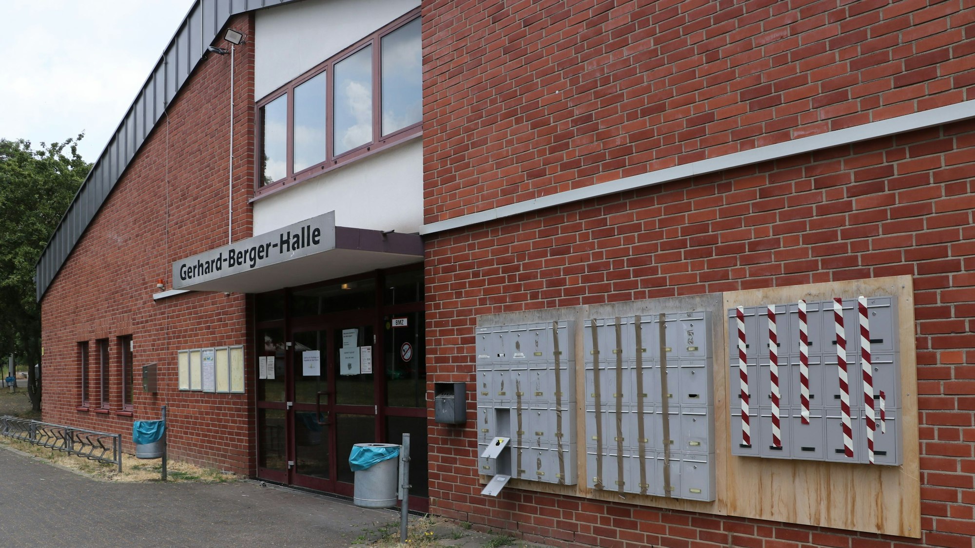 Neben dem Eingang der Sporthalle sind Briefkästen angebracht.