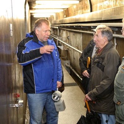 Ein Mitarbeiter des Wupperverbands erläutert Teilnehmern einer Führung das Innere des Kontrollgangs im Staudamm der Großen Dhünn-Talsperre.