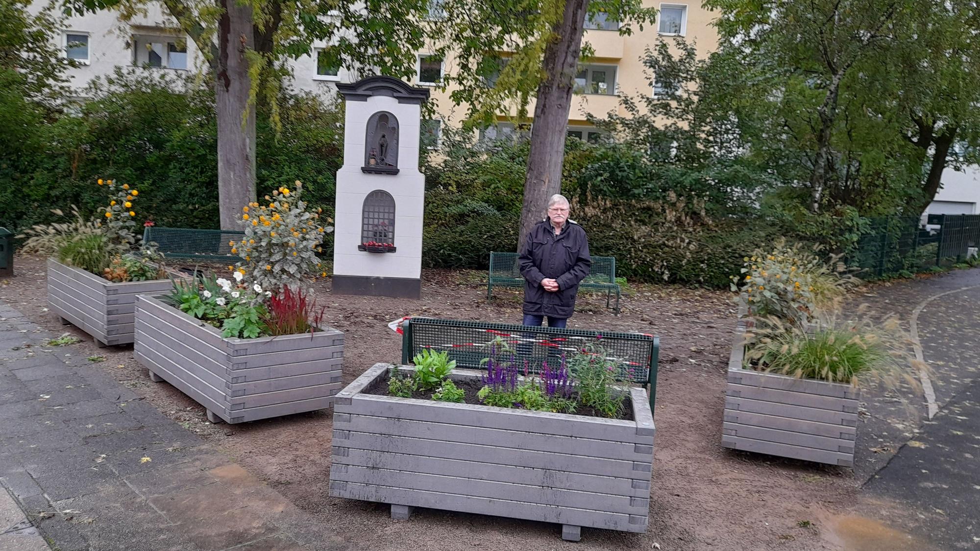 Dr. Herbert Clasen steht auf dem fertigen Platz vor dem Bildstock.