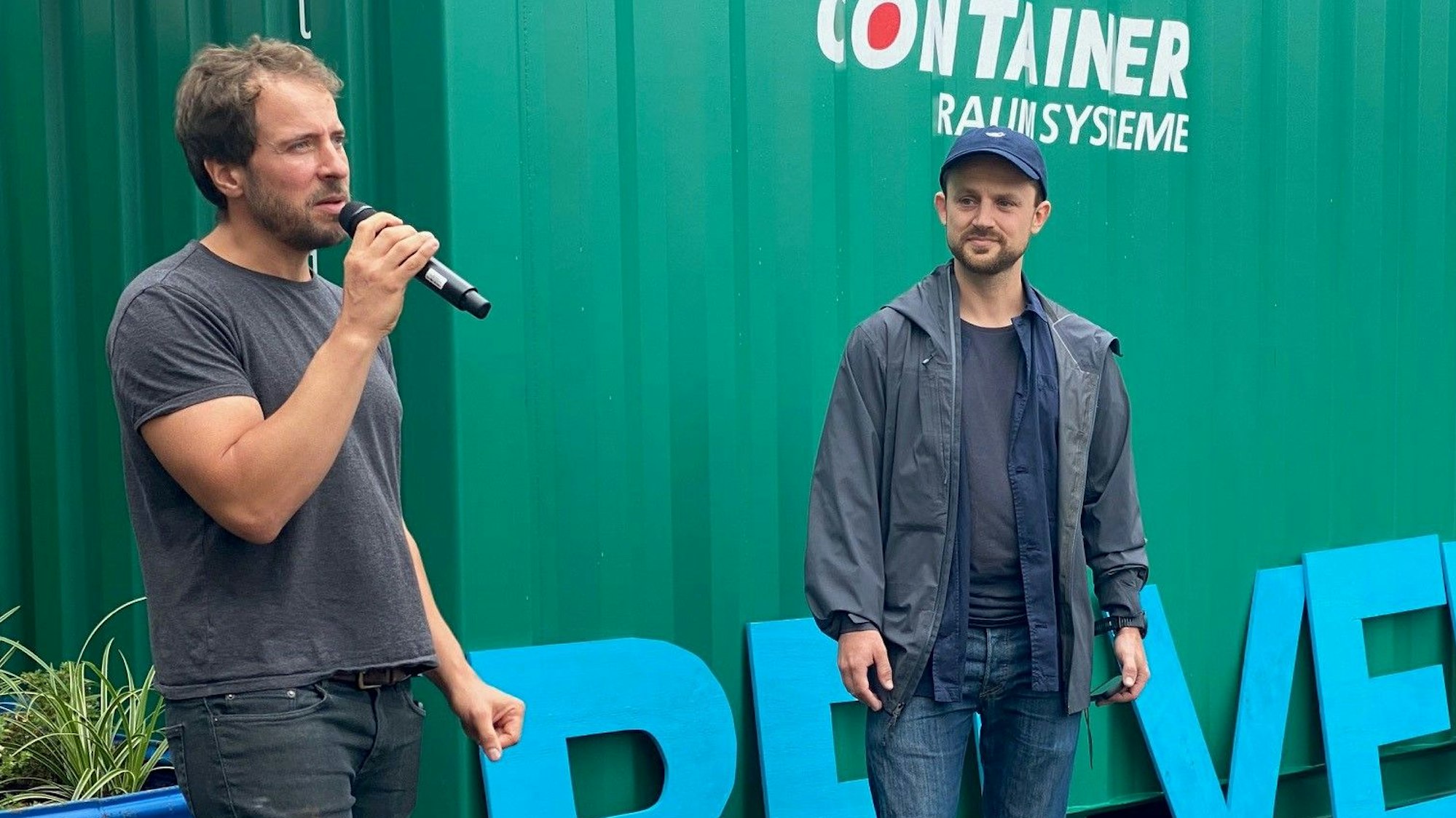 Thorsten Kleinschmidt (l.) am Mikrofon und Künstler Jan Kamensky. Hinter ihnen (nur teilweise sichtbar) die Buchstaben des Wortes „Belvedere“.