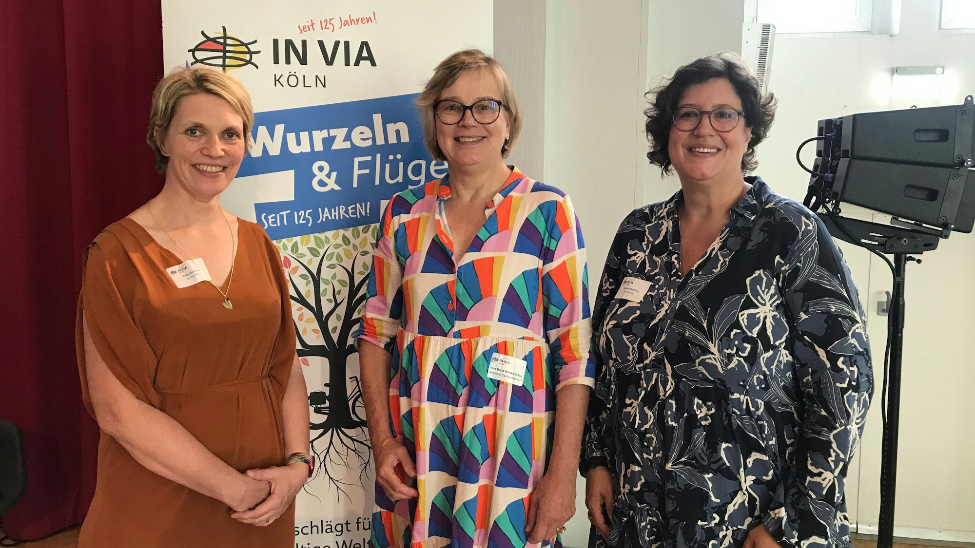 Katja Schauen, Eva Maria Welskop-Deffaa und Andrea Redding stehen vor einem „In Via“-Schild und lächeln in die Kamera.
