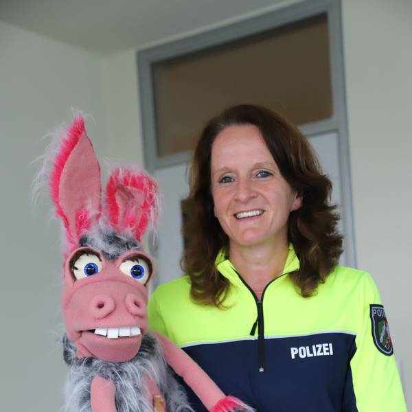 Eine Polizistin hält eine rosa Pferdepuppe.