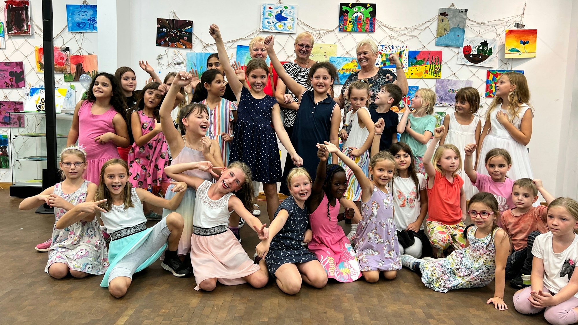 Die Vernissage zur Ausstellung City Color in Leverkusen-Wiesedorf mit Barbara Gorel (hinten rechts) und den Kinder der Gemeinschaftsgrundschule Im Steinfeld.