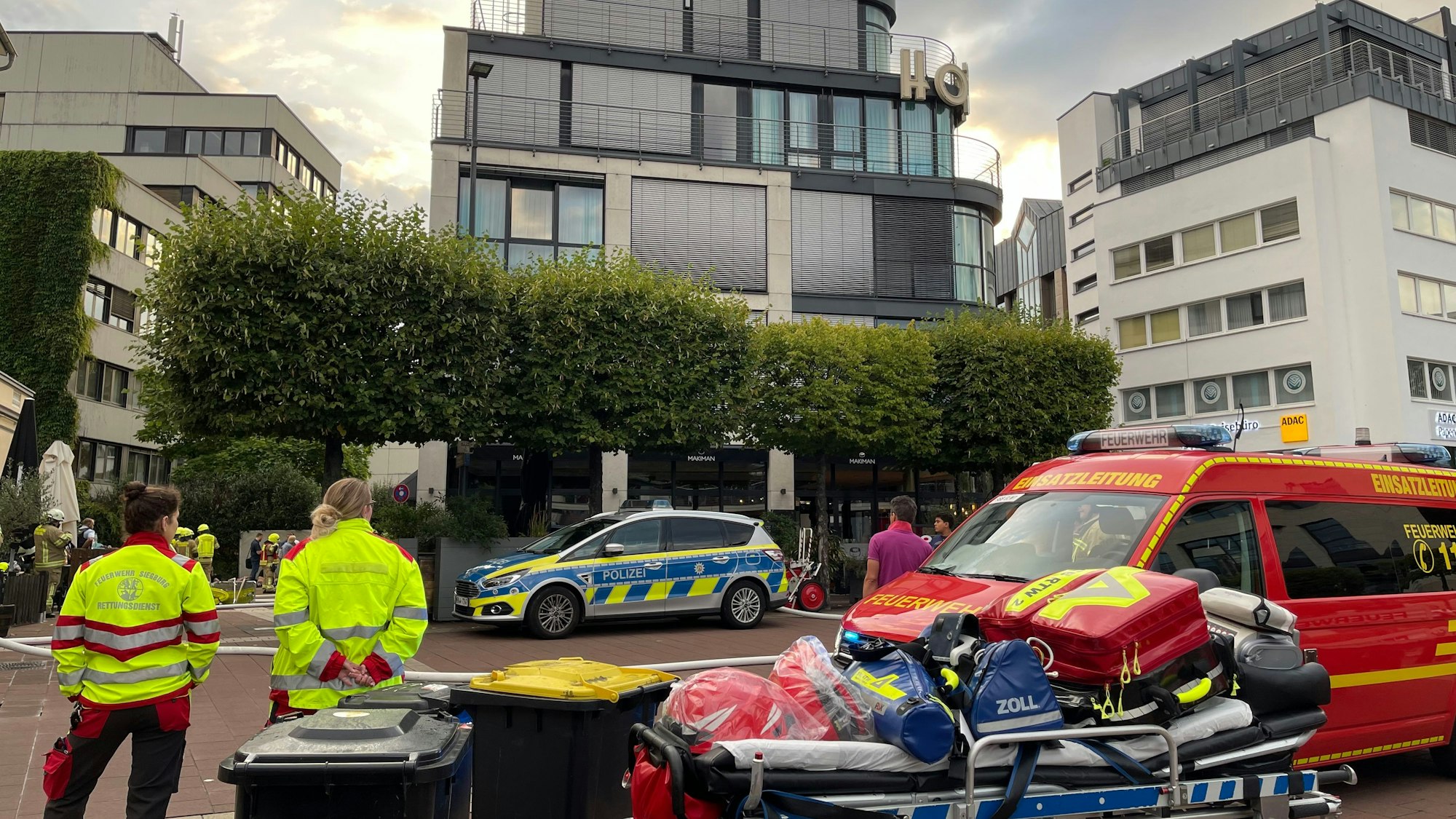 Feuerwehr, Polizei und Rettungskräfte stehen vor einem Hotel.