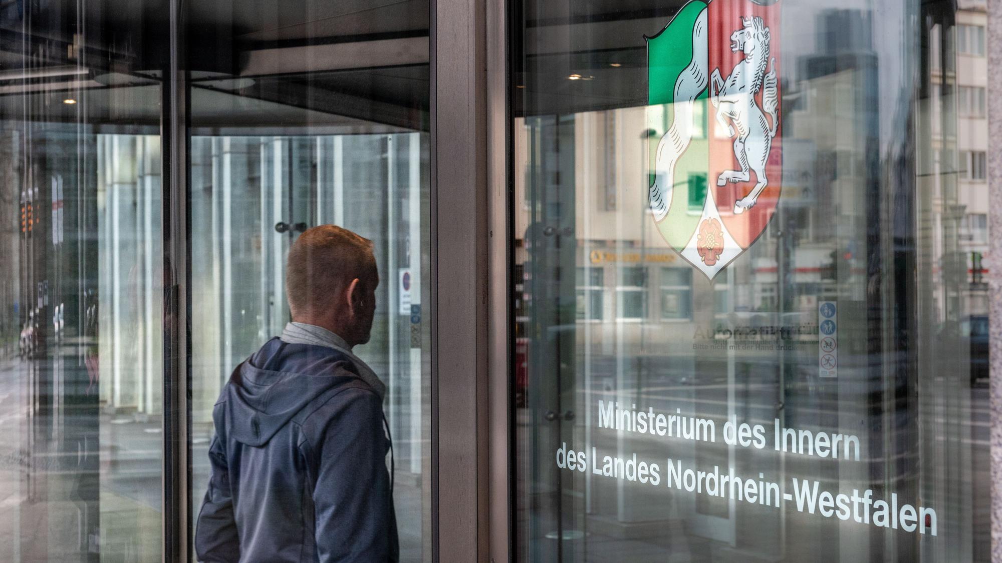 Ein Mann steht am Eingang des Innenministeriums NRW