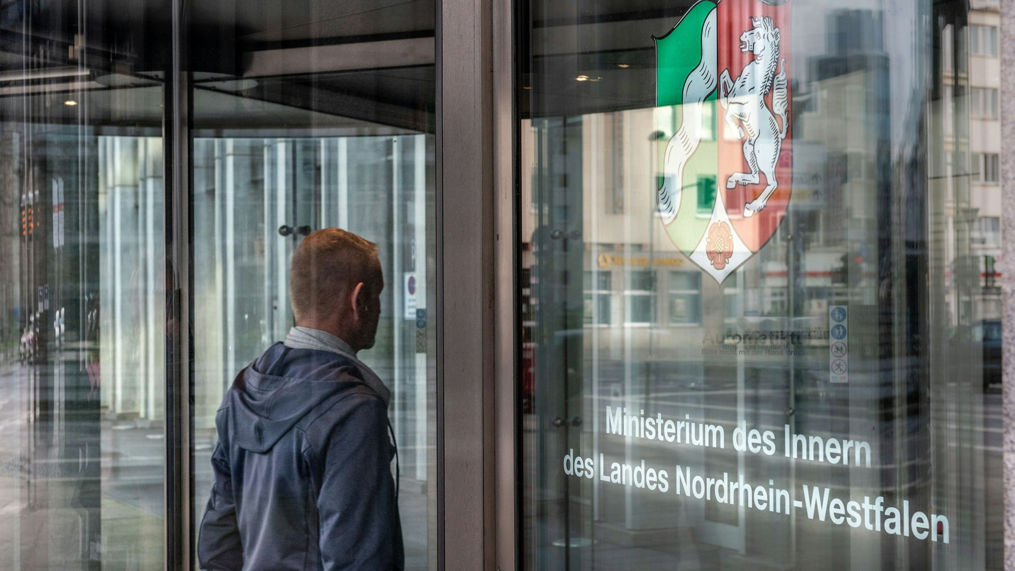 Ein Mann steht am Eingang des Innenministeriums NRW
