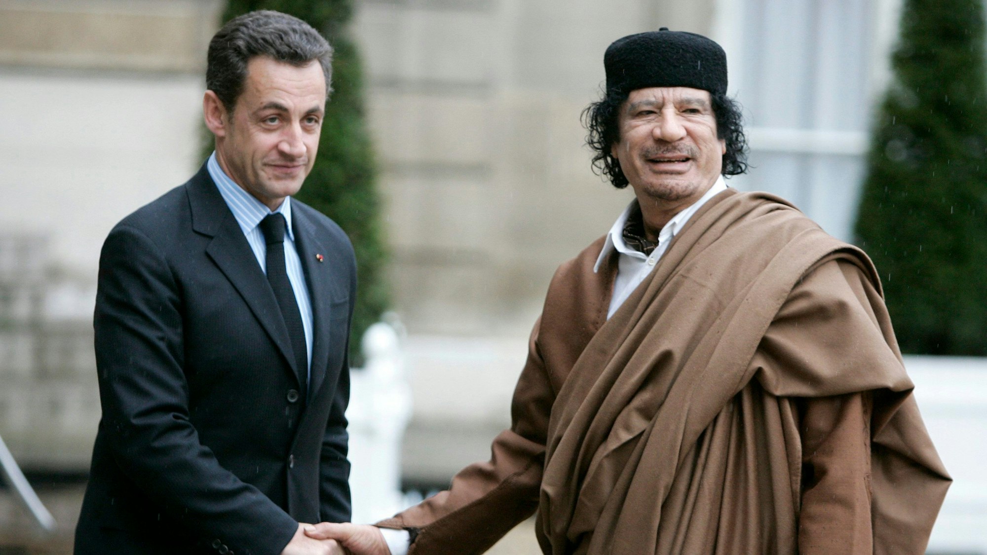 Der französische Präsident Nicolas Sarkozy, links, begrüßt den libyschen Staatschef Oberst Moammar Gaddafi bei seiner Ankunft im Elysee-Palast in Paris am 10. Dezember 2007.