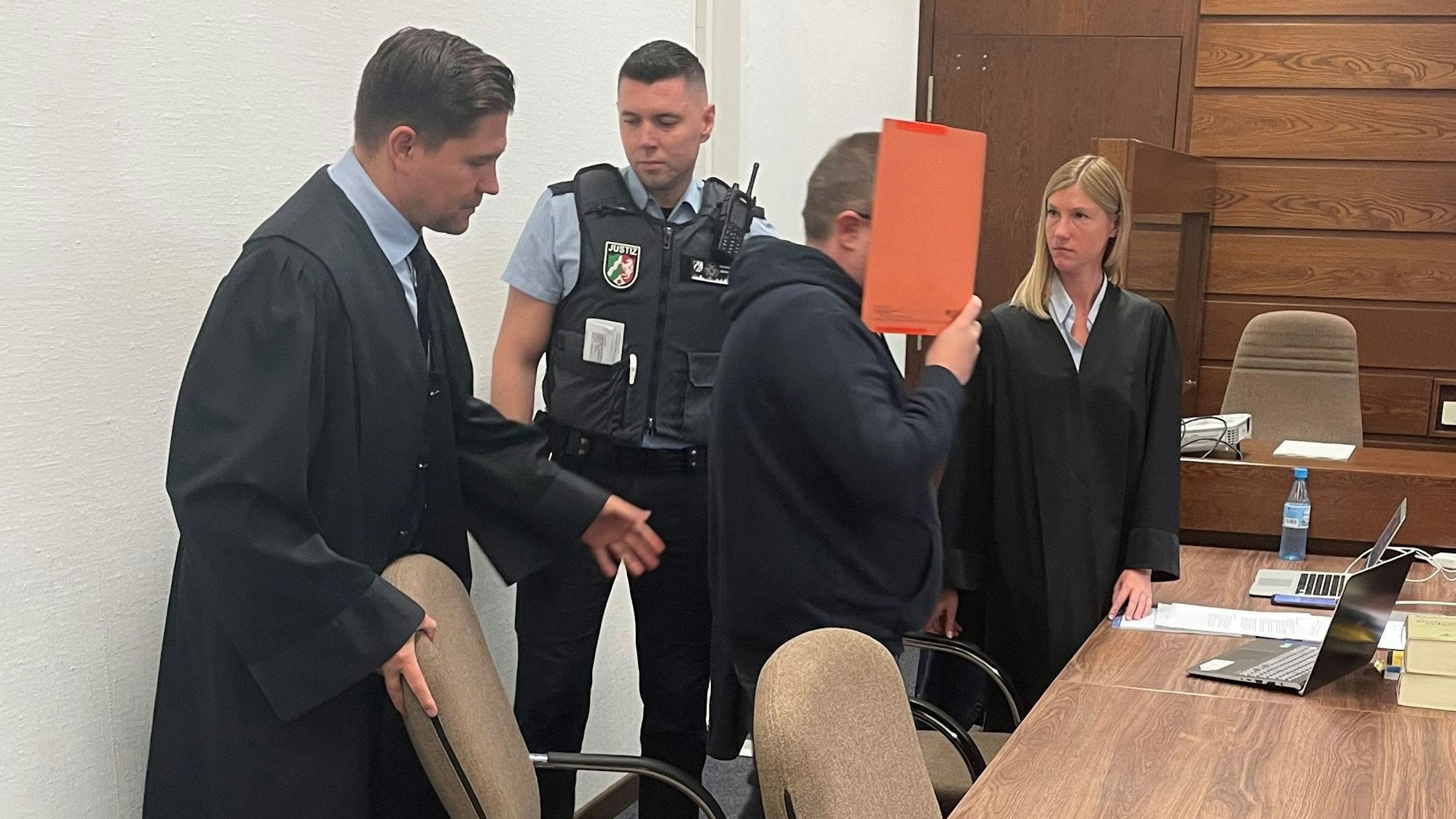 Der Angeklagte mit Verteidiger Jan-Maximilian Zeller, Verteidigerin Stephanie Ablass und Wachtmeister im Landgericht Köln.