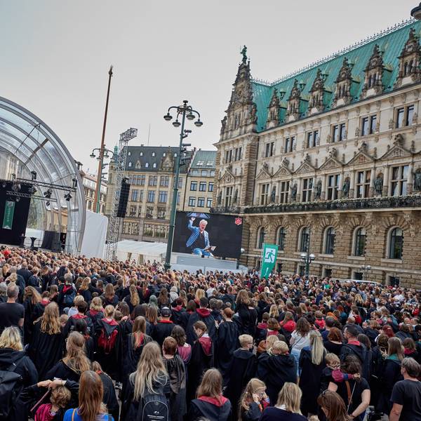 Rufus Beck, Schauspieler, liest auf der Bühne am Rathausmarkt aus Harry Potter. Vor der Bühne stehen über 1000 Menschen als Harry Potter verkleidet mit Umhängen in schwarz-rot.