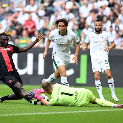 Mönchengladbachs Torhüter Jonas Omlin (r) und Leverkusens Victor Boniface kämpfen um den Ball.