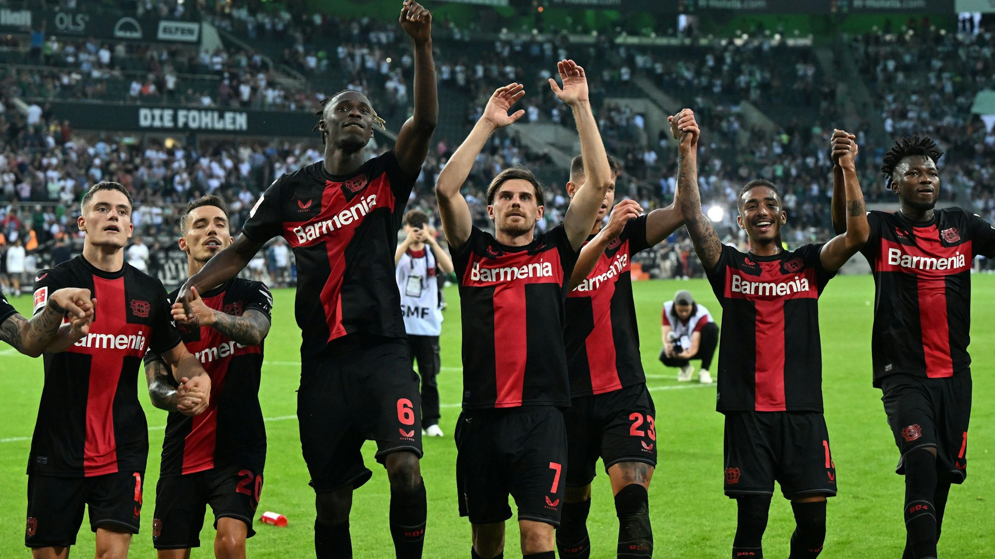 Die Spieler der Werkself feiern den Sieg mit ihren Fans in Mönchengladbach.