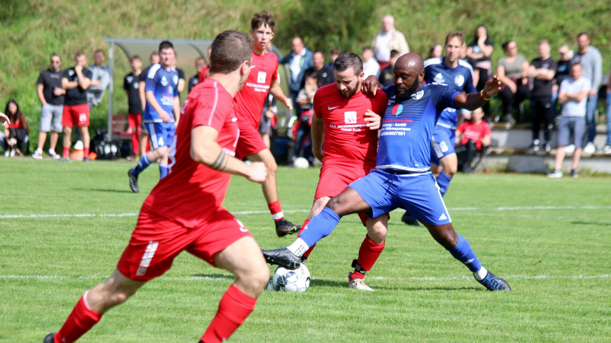 Zwei Spieler im Zweikampf um den Ball. Im Hintergrund sind die Zuschauer zu sehen.