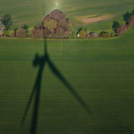 Der Schatten einer Windenergieanlage ist auf einem Feld im Landkreis Oder-Spree zu sehen (Luftaufnahme mit einer Drohne).
