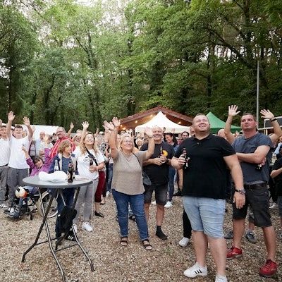 Auf einem Festplatz recken Konzertbesucher ihre Arme in die Höhe, damit sie bei einer Zählung per Drohne registriert werden.