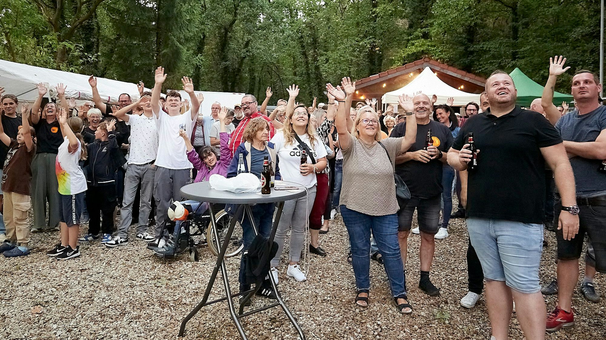 Auf einem Festplatz recken Konzertbesucher ihre Arme in die Höhe, damit sie bei einer Zählung per Drohne registriert werden.