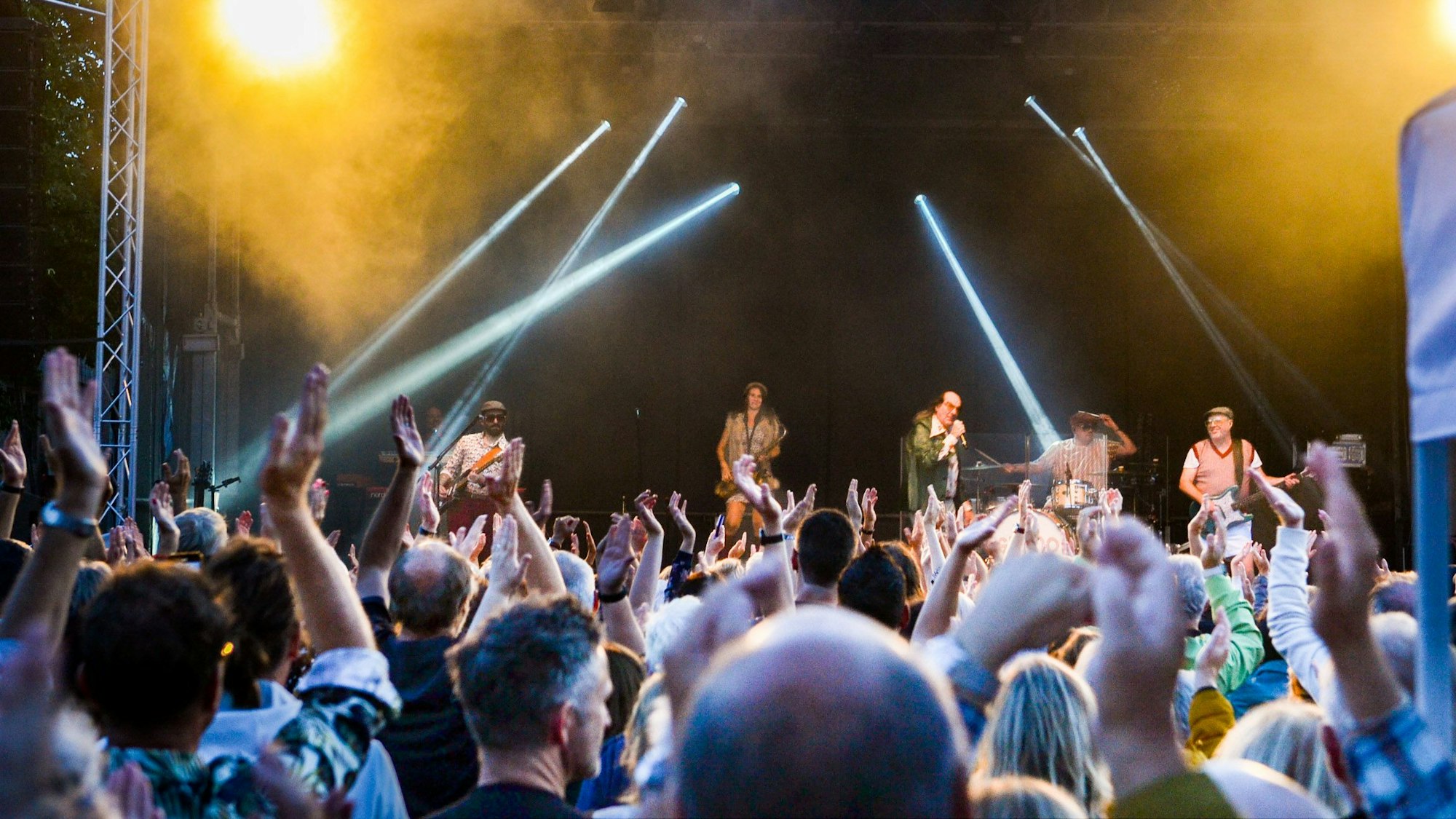 Das Bild zeigt einen Teil des Publikums und auf der Bühne singt Guildo Horn.
