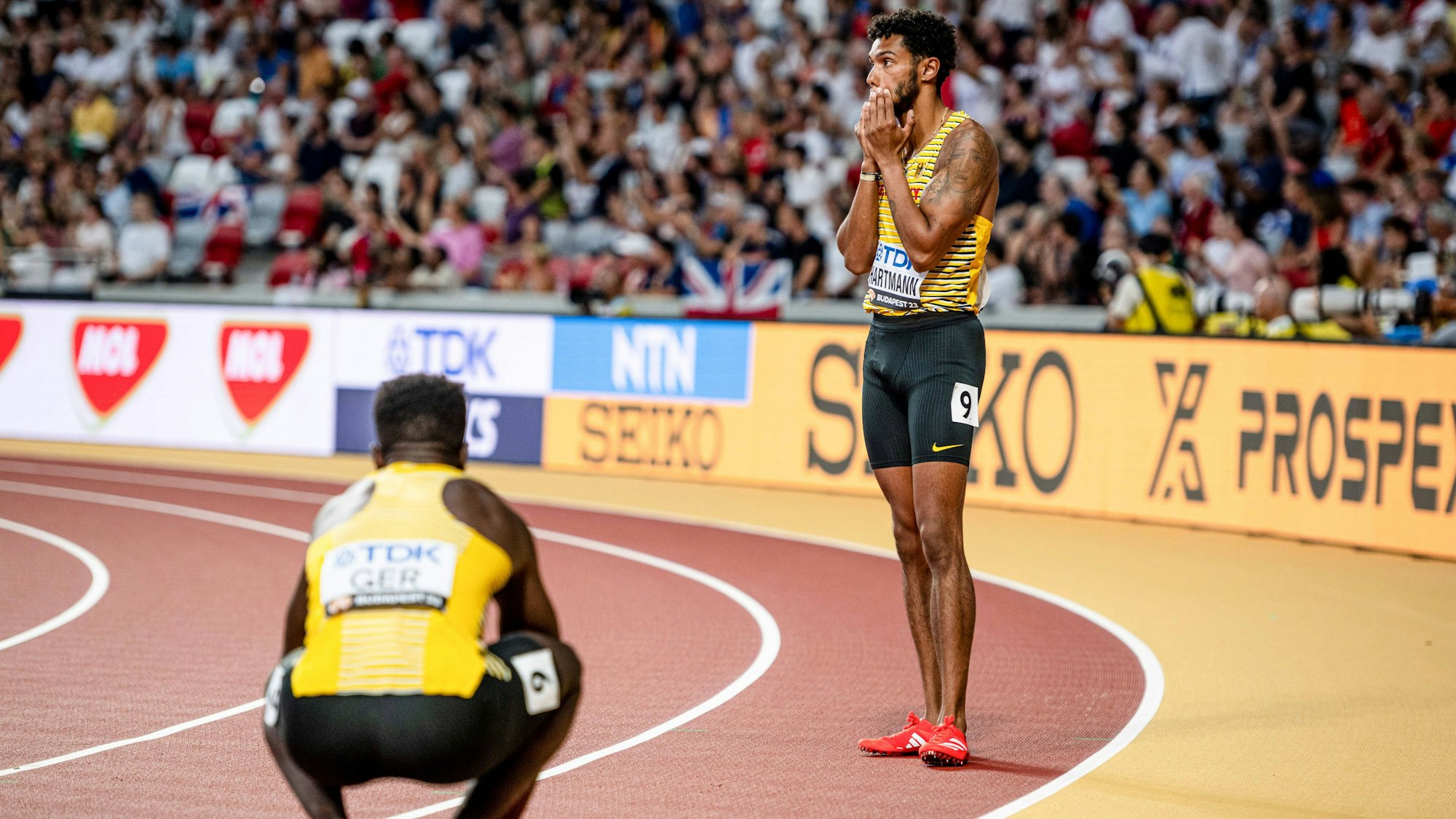 Der Kölner Sprinter Joshua Hartmann fasst sich vor Entsetzen ans Gesicht. Soeben hat er den Staffelstab fallengelassen.
