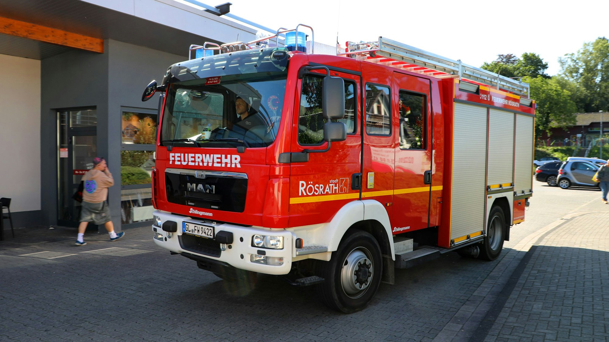 Ein Feuerwehrfahrzeug der Feuerwehr Rösrath fährt mit Blaulicht los.