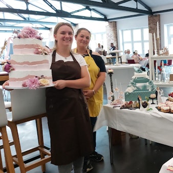 Konditorgesellin Sophie Funken (l.) und ihre Chefin Stephanie Schmidt-Eisenbach von Schmidt's Backstübchen zeigen Hochzeitstorten und Konditorwaren.
