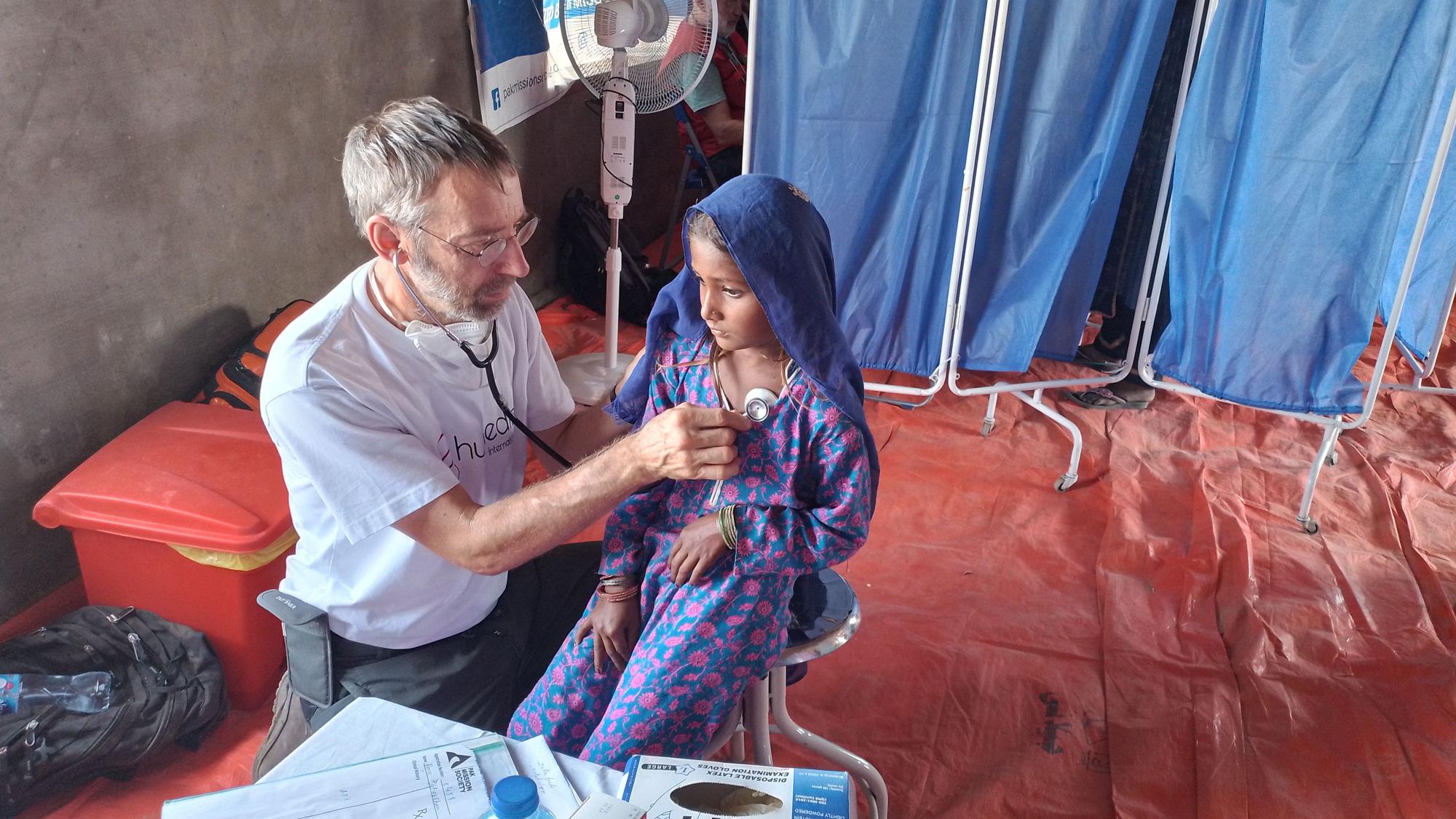 Der Niederkasseler Allgemeinmediziner Michael Brinkmann untersucht in einem Krankenhaus in Pakistan ein kleines Mädchen mit einem Stethoskop.