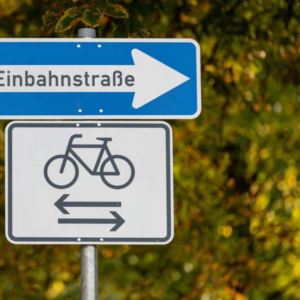 Das Bild zeigt ein Einbahnstraßen-Schild. Darunter: eine Abbildung eines Fahrrads. Pfeile zeigen in beide Richtungen.