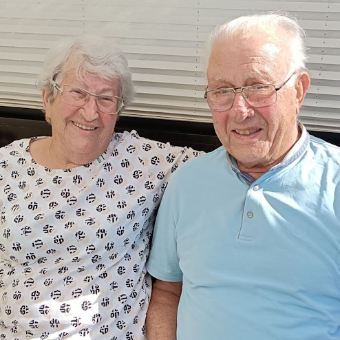 Das Ehepaar Helmuth und Irmgard Friese sitzt nebeneinander auf einer Bank.