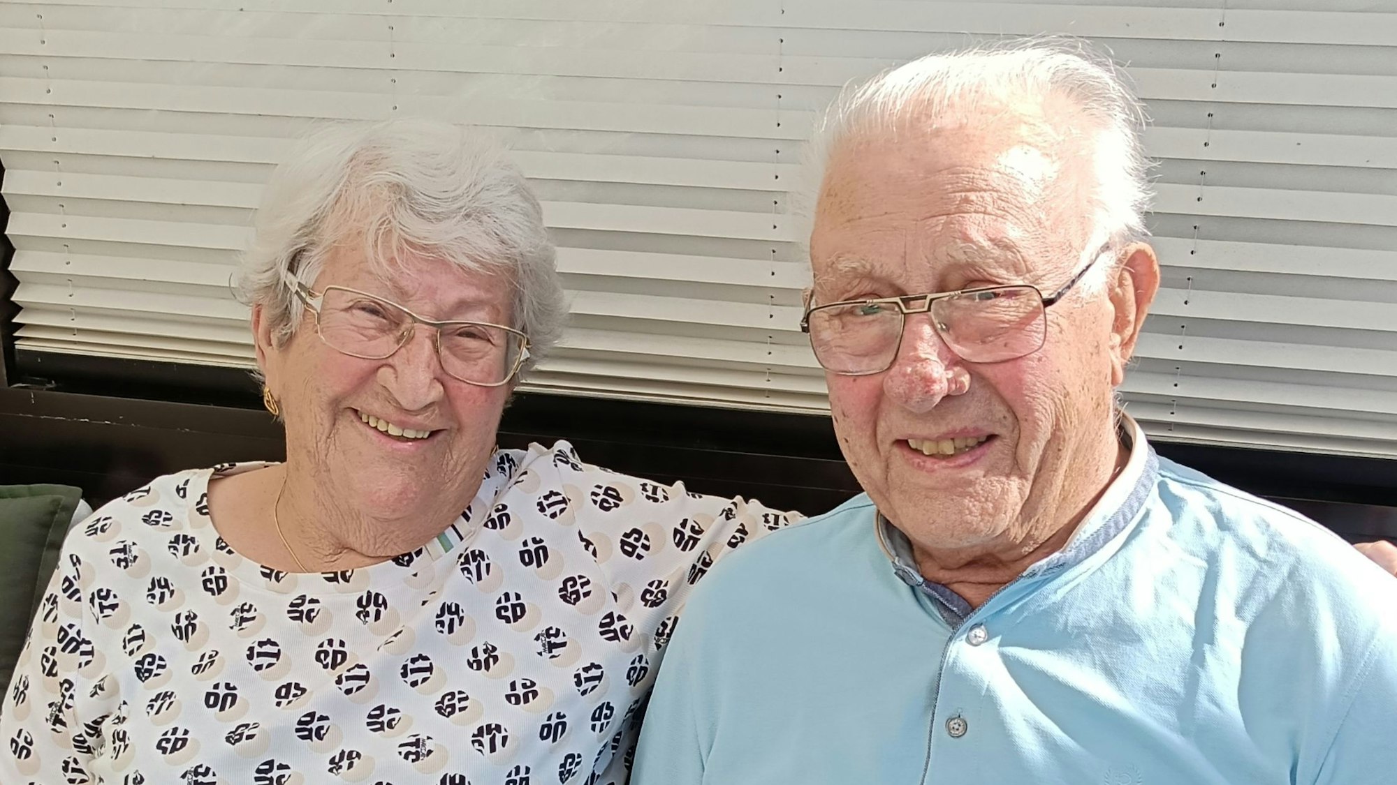 Das Ehepaar Helmuth und Irmgard Friese sitzt nebeneinander auf einer Bank.