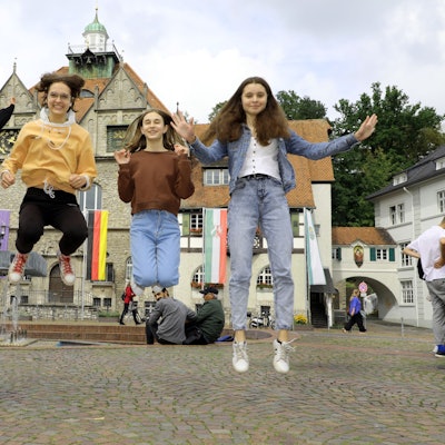 Vier Mädchen springen für die Fotoaufnahme in die Luft.