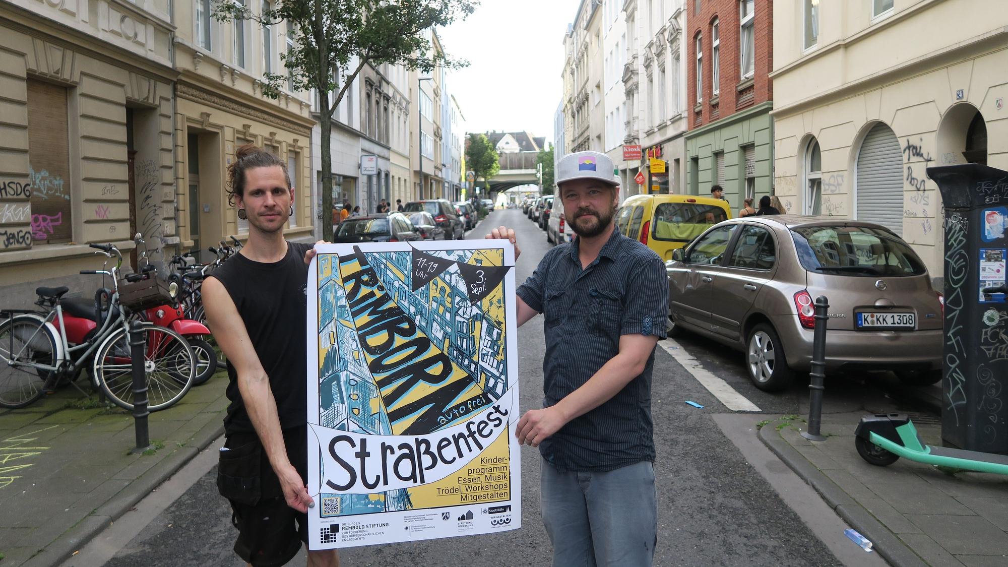 Zwei Männer halten ein Plakat in die Luft.